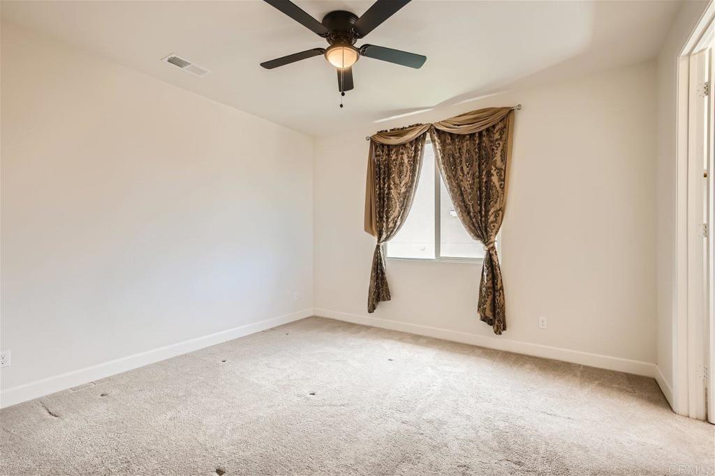 431 Machado Way Vista, CA 92083 - Photo 25 of 36 a view of an empty room with a ceiling fan