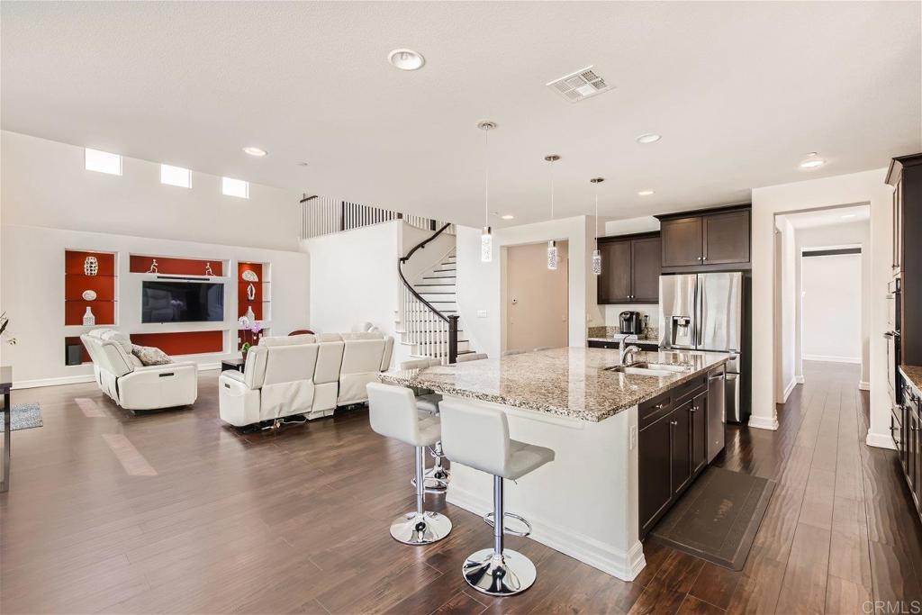 431 Machado Way Vista, CA 92083 - Photo 8 of 36 a kitchen with stainless steel appliances kitchen island granite countertop a stove and a sink