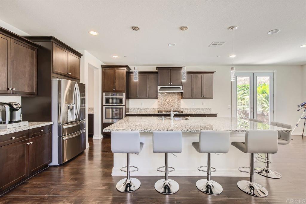 431 Machado Way Vista, CA 92083 - Photo 10 of 36 a kitchen with stainless steel appliances kitchen island granite countertop a kitchen island hardwood floor and a sink