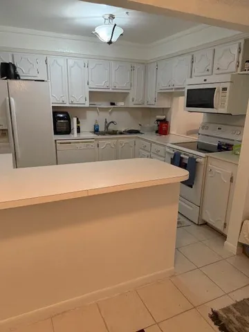 a kitchen with stainless steel appliances a refrigerator a stove a sink and white cabinets