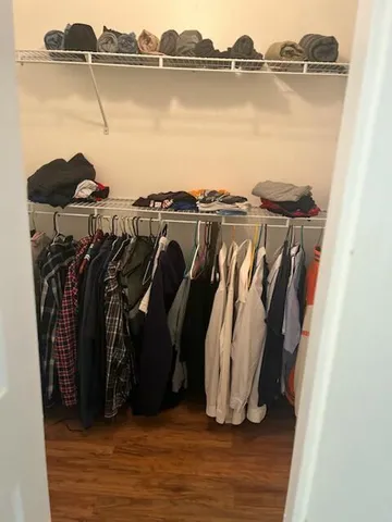 a view of walk in closet with clothes and shoes