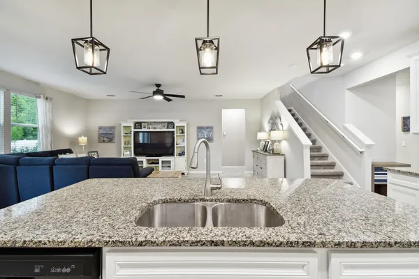 a living room with furniture kitchen area and a window
