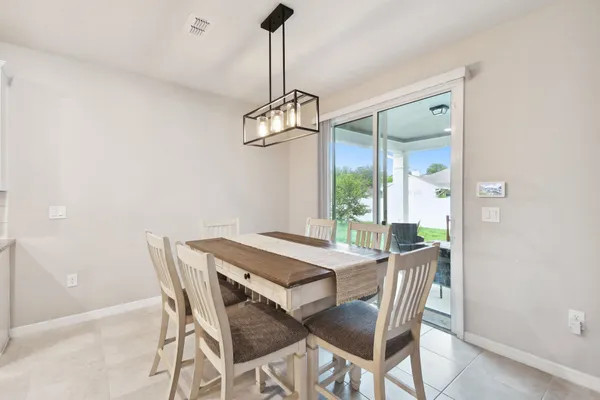 a living room with furniture kitchen view and a chandelier