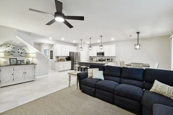 a bedroom with a bed and a ceiling fan with a large window