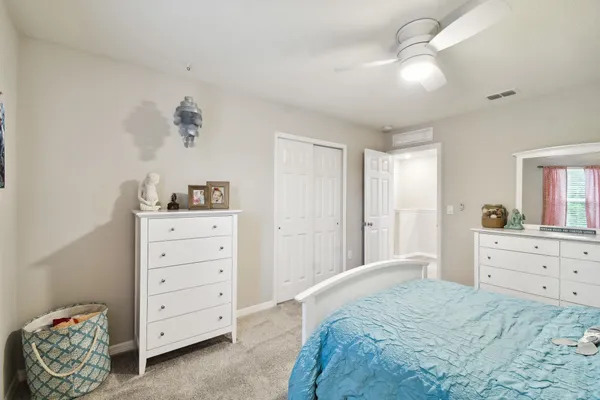 a bedroom with a bed and a painting on the wall