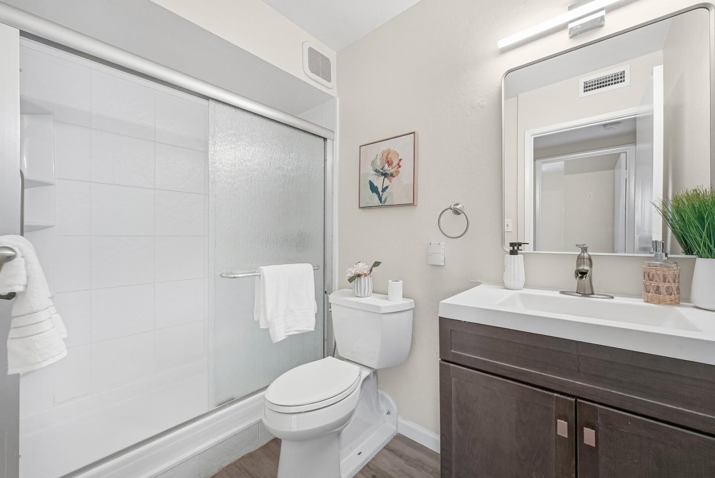 701 North Rengstorff Avenue, Unit 7 Mountain View, CA 94043 - Photo 24 of 32 a bathroom with a toilet a sink a mirror and vanity