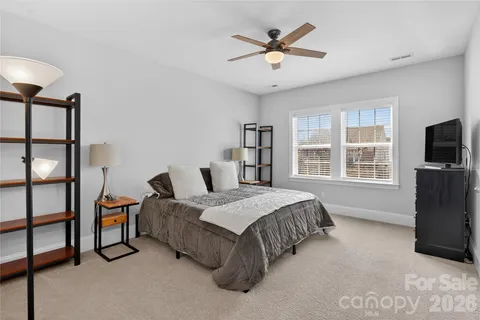 a spacious bedroom with a bed a dresser and a flat screen tv