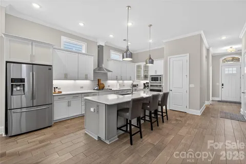 a kitchen with kitchen island granite countertop a sink cabinets and stainless steel appliances