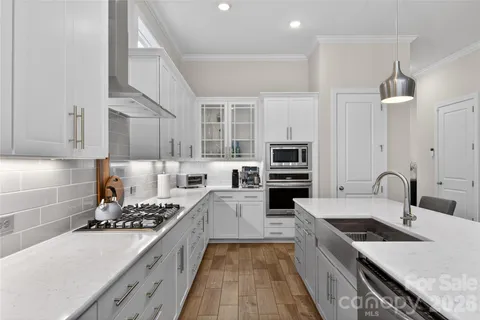 a large kitchen with stainless steel appliances granite countertop a stove and a sink