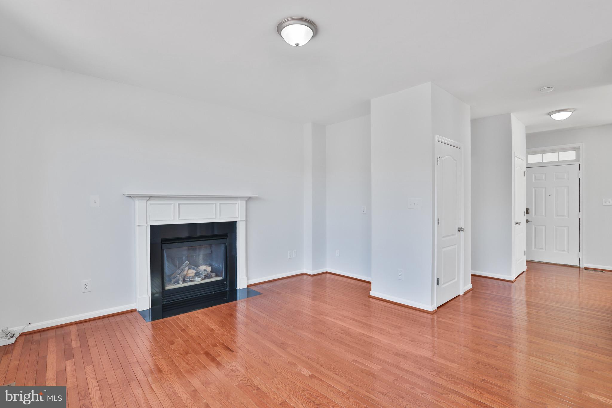 26215 Ocala Circle Chantilly, VA 20152 - Photo 15 of 50 a view of an empty room with wooden floor fireplace and a window