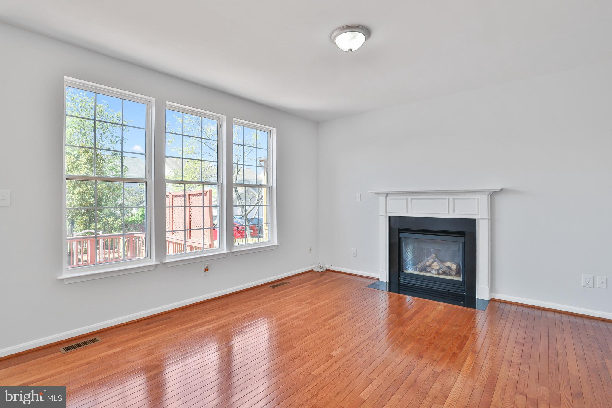 26215 Ocala Circle Chantilly, VA 20152 - Photo 16 of 50 an empty room with wooden floor fireplace and windows