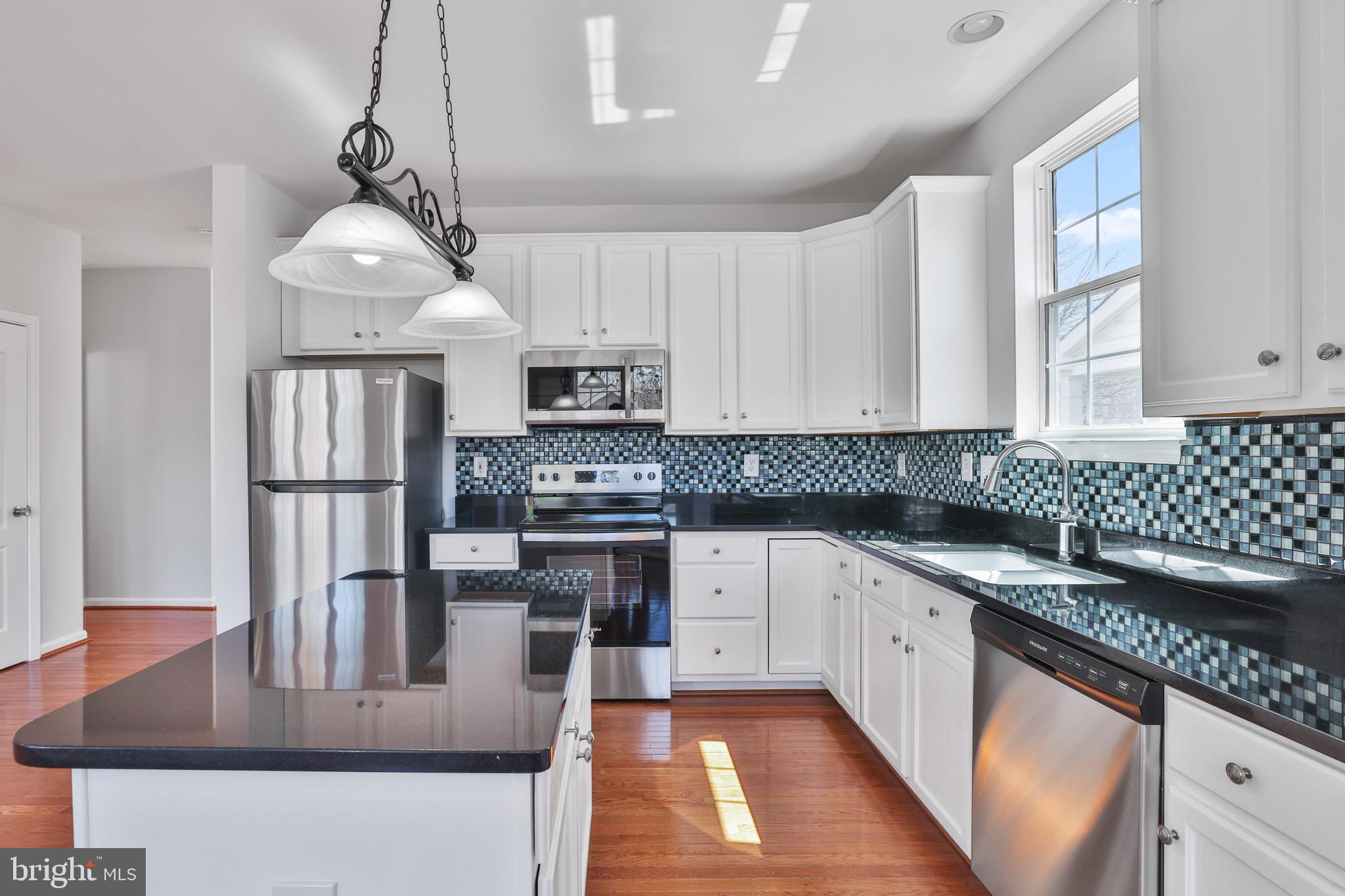 26215 Ocala Circle Chantilly, VA 20152 - Photo 18 of 50 a kitchen with stainless steel appliances granite countertop a sink stove and refrigerator