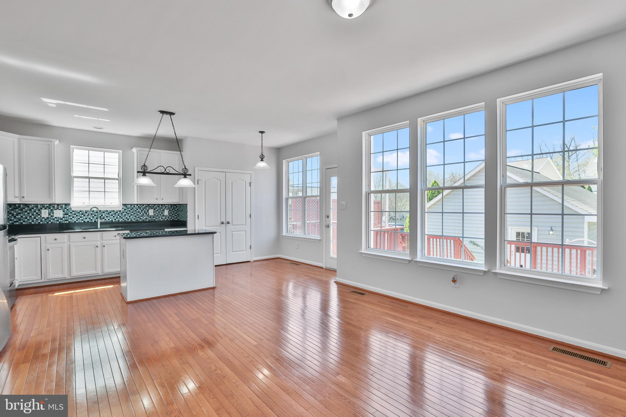 26215 Ocala Circle Chantilly, VA 20152 - Photo 20 of 50 a large kitchen with granite countertop a stove a sink a refrigerator and white cabinets with wooden floor