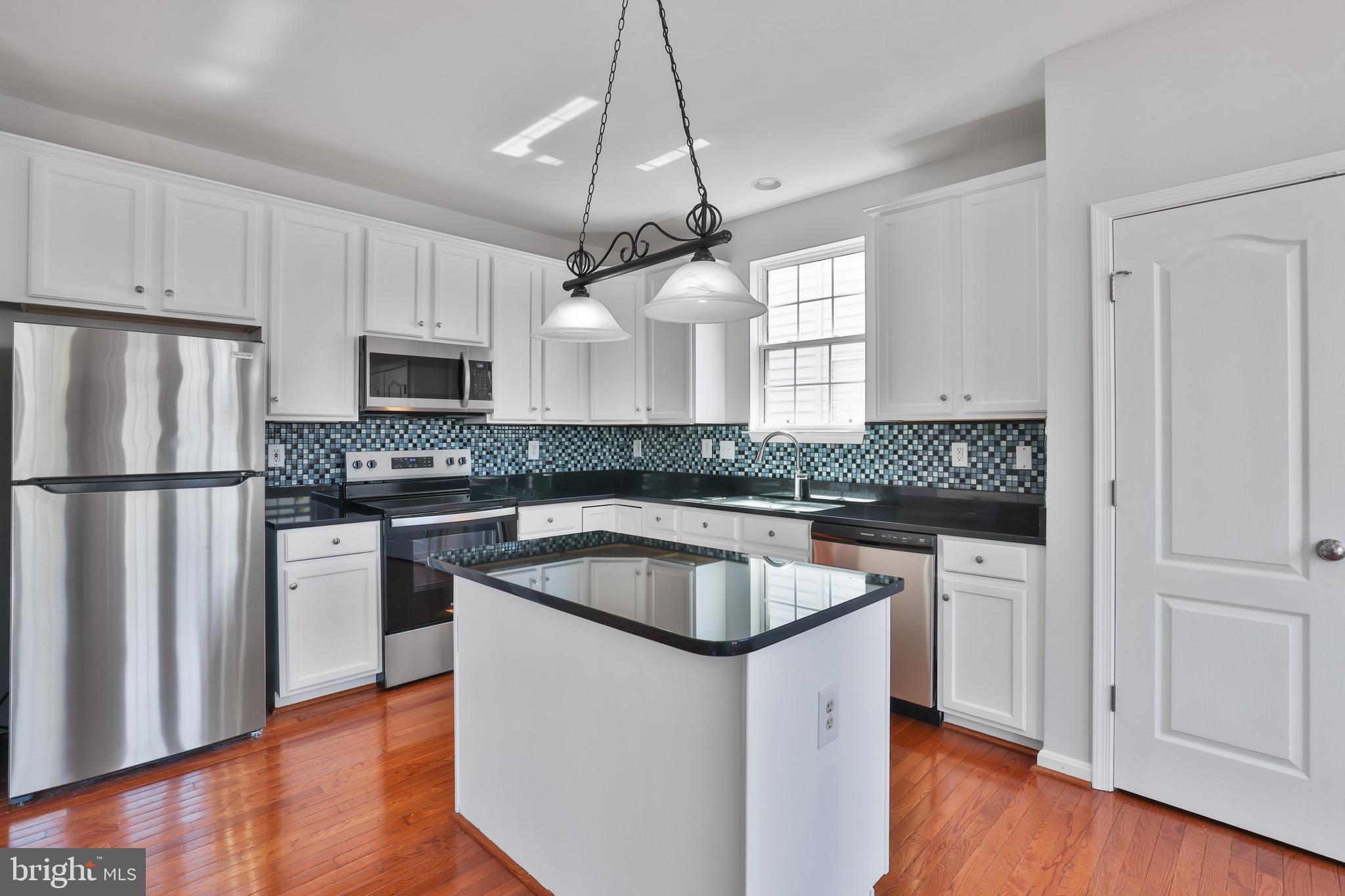 26215 Ocala Circle Chantilly, VA 20152 - Photo 22 of 50 a kitchen with kitchen island granite countertop a sink a counter space stainless steel appliances and cabinets