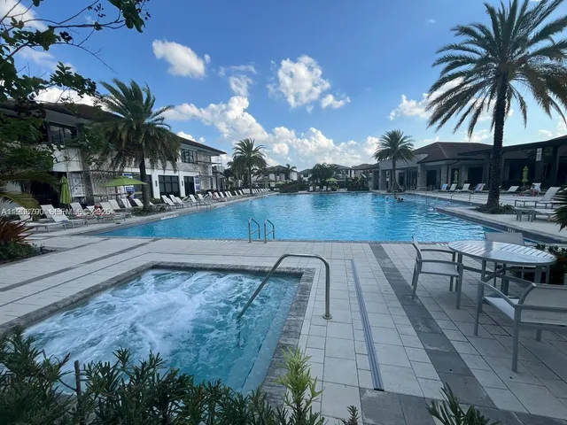 a view of a swimming pool with a table and chairs under an umbrella