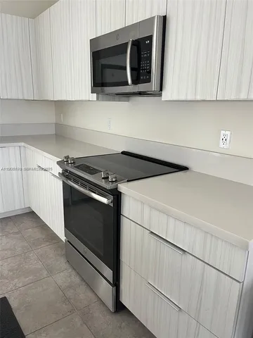 a kitchen with stainless steel appliances granite countertop a stove microwave and sink