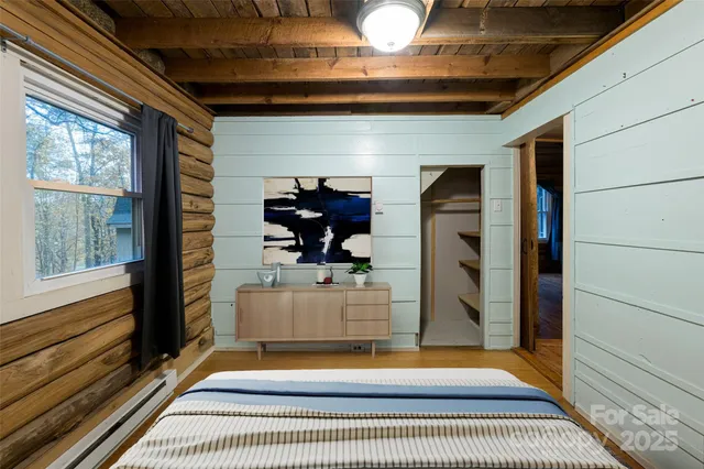 a living room with furniture a flat screen tv and floor to ceiling window