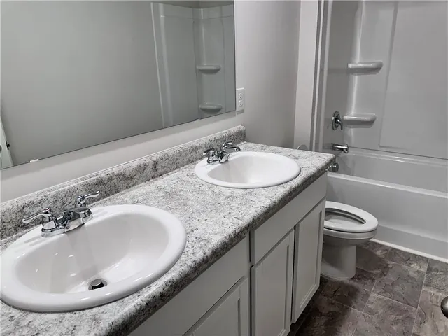 a kitchen with white cabinets and black appliances