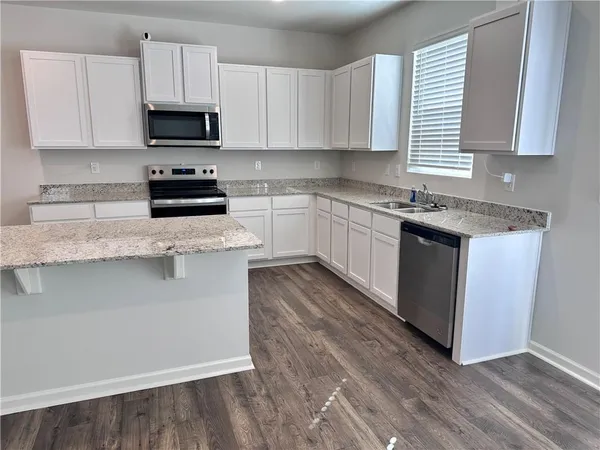 a kitchen with granite countertop wooden cabinets and a stove