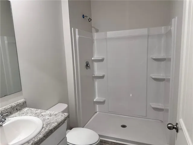 a bathroom with a granite countertop toilet sink and shower