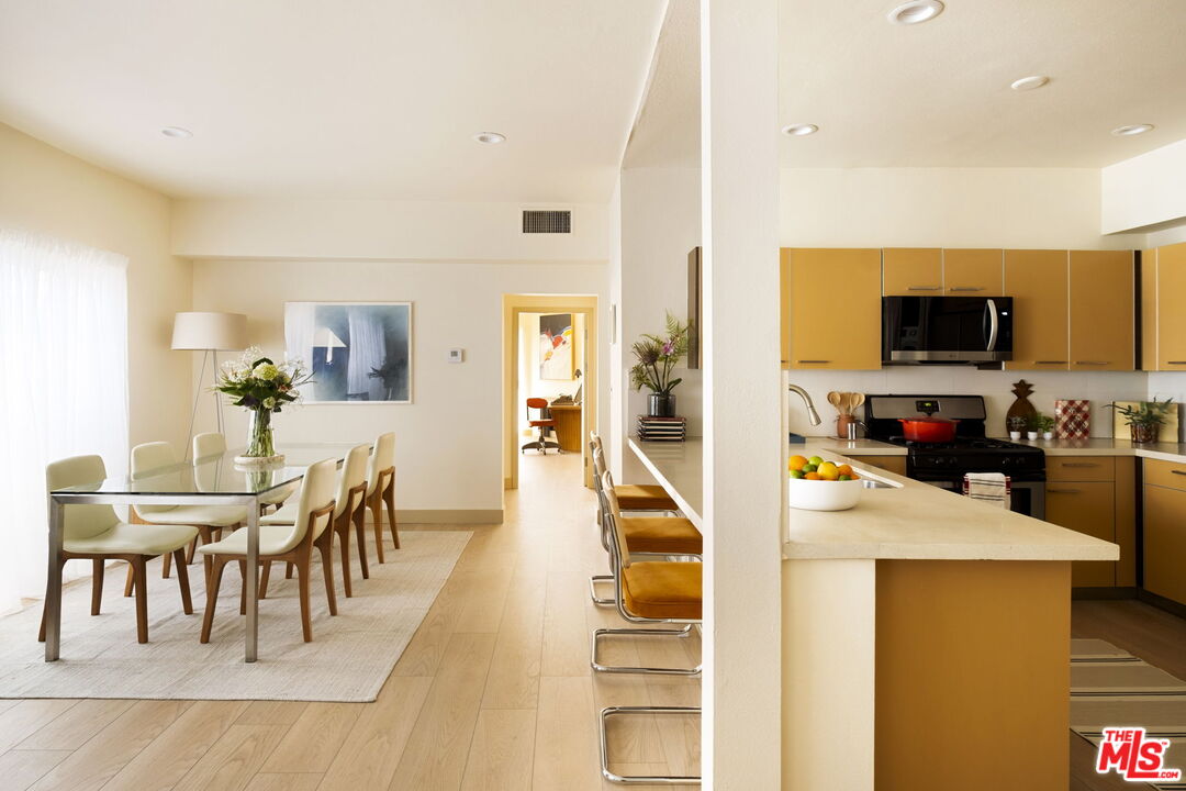a view of a dining room with furniture a kitchen and chandelier