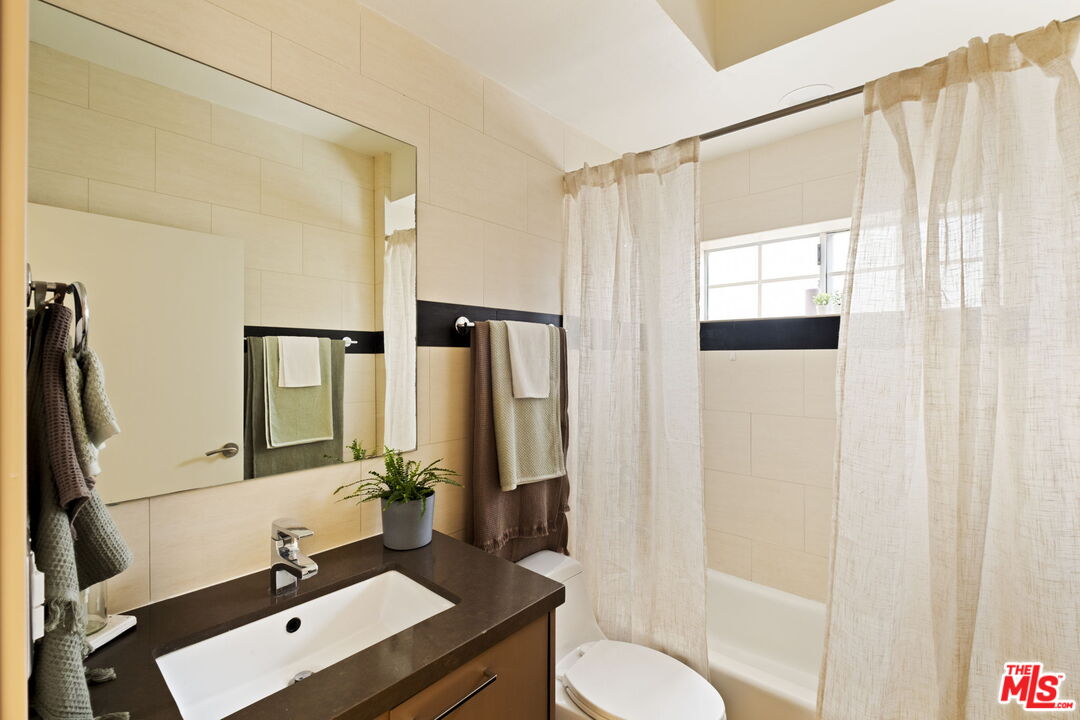 1717 Malcolm Avenue, Unit 303 Los Angeles, CA 90024 - Photo 28 of 34 a bathroom with a sink vanity mirror and toilet