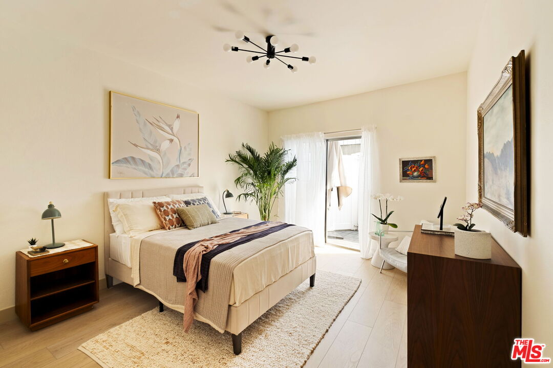 1717 Malcolm Avenue, Unit 303 Los Angeles, CA 90024 - Photo 29 of 34 a spacious bedroom with a bed and a chandelier