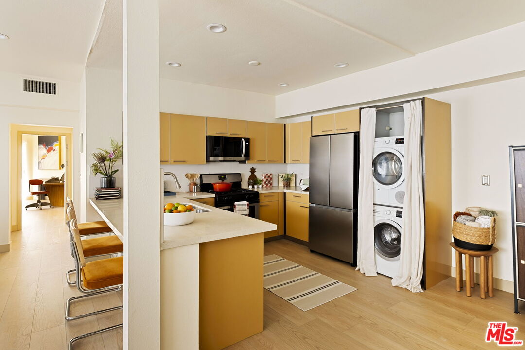 1717 Malcolm Avenue, Unit 303 Los Angeles, CA 90024 - Photo 6 of 34 a view of a kitchen with a refrigerator a sink dishwasher and a fireplace