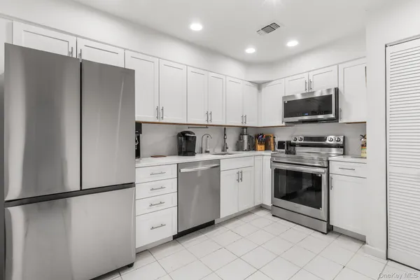 a kitchen with white cabinets and white appliances