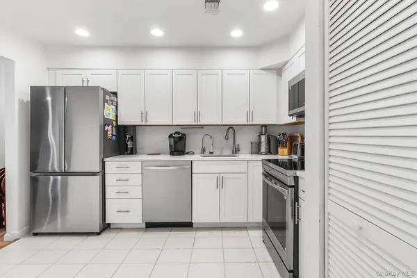 a kitchen with white cabinets and white appliances