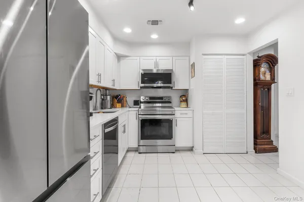 a kitchen with white cabinets and stainless steel appliances