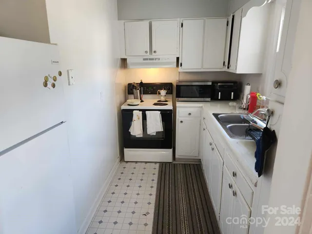 a kitchen with a white stove top oven and sink