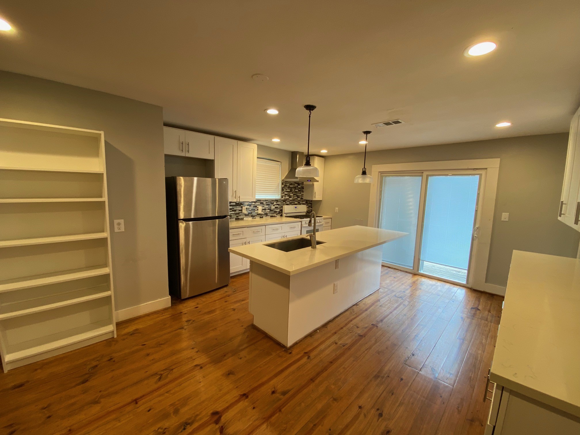 3209 Milburn Street Houston, TX 77021 - Photo 11 of 45 a large white kitchen with wooden floors and stainless steel appliances