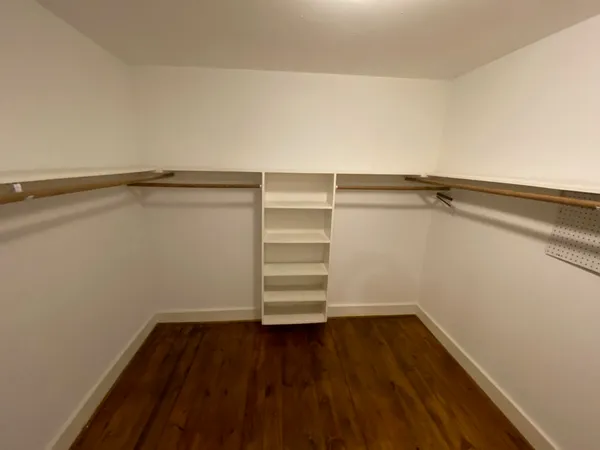 a view of a room with wooden floor and white walls