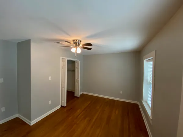 a view of an empty room with wooden floor