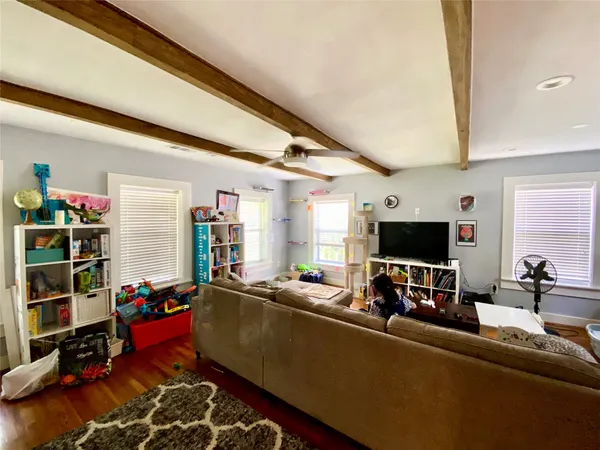 a living room with furniture a flat screen tv and gym equipment