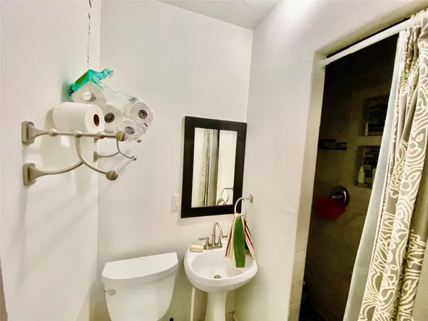 a bathroom with a sink toilet and mirror