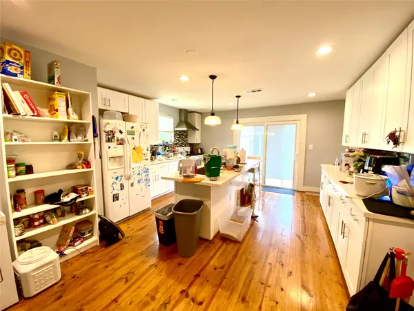 a large white kitchen with lots of appliances a sink and cabinets