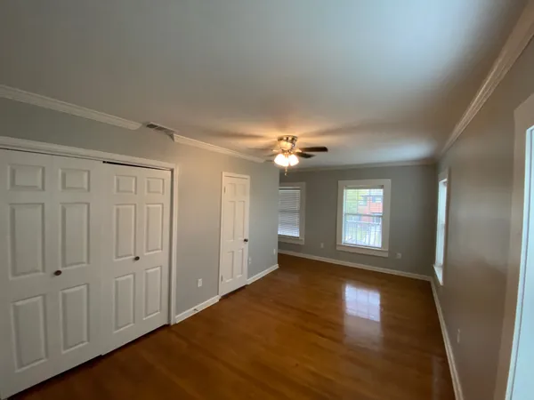 a view of empty room with window and wooden floor
