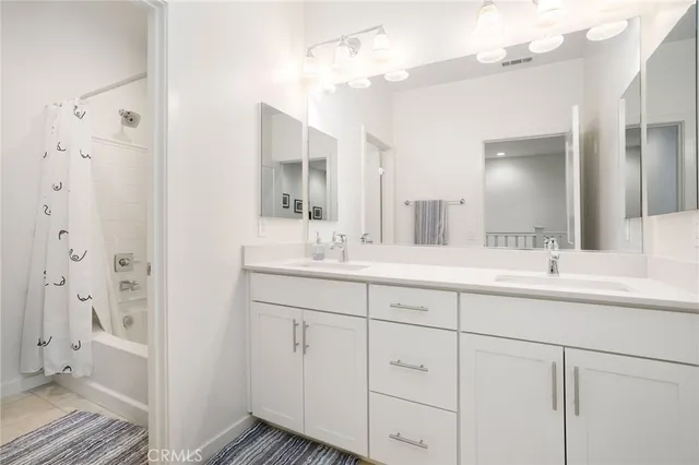 a bathroom with double vanity sink a mirror a vanity and a shower