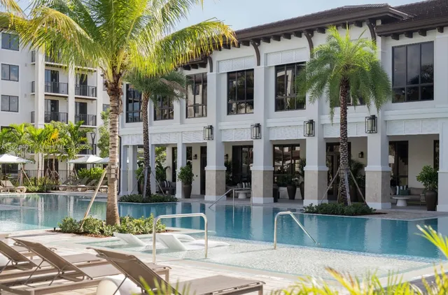 a view of a house with a swimming pool and sitting area