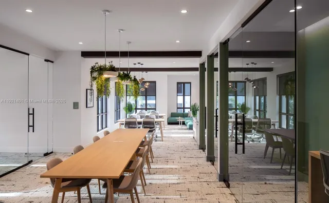 a dining hall with stainless steel appliances a dining table and chairs