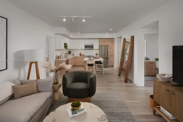 a living room with furniture a flat screen tv and a large window
