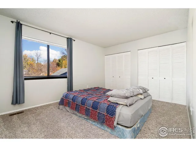 a bedroom with a bed and a painting on the wall