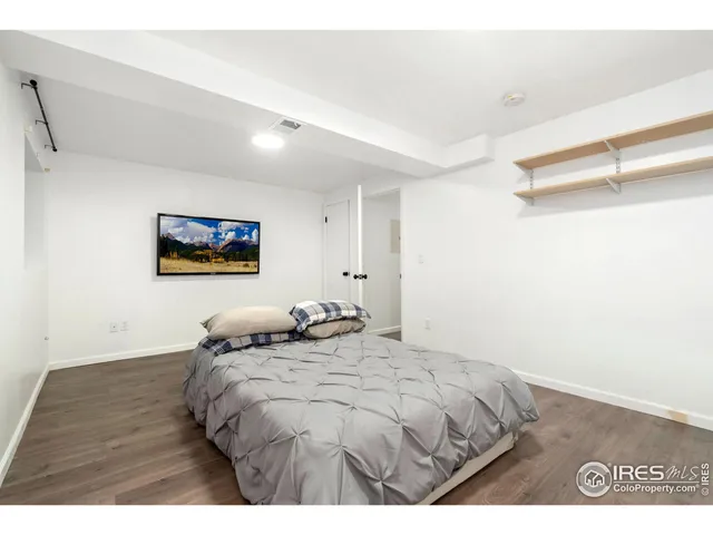 a bedroom with a bed and a painting on the wall