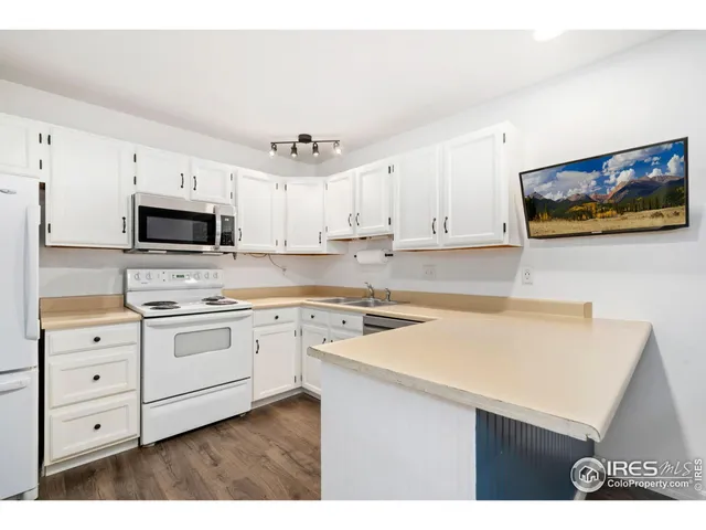 a kitchen with granite countertop white cabinets and white appliances