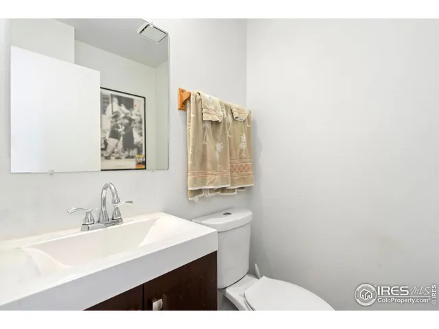 a bathroom with a sink mirror and a toilet