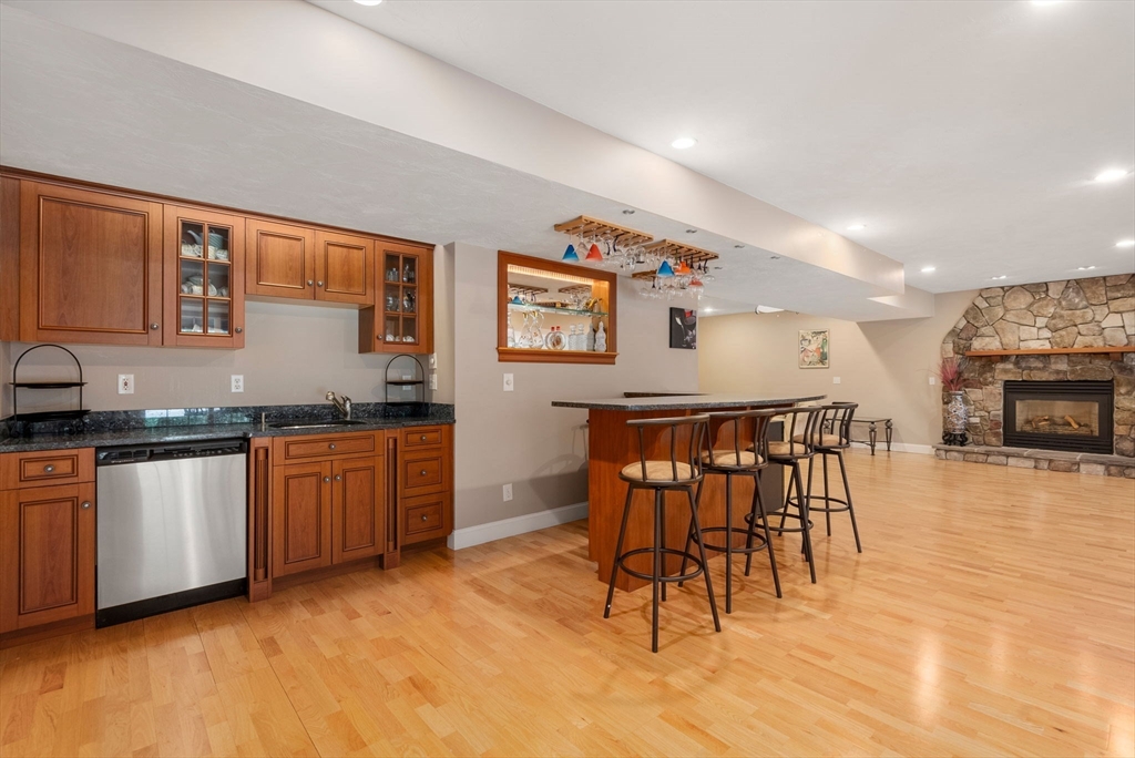 15 Beaver Brook Road Canton, MA 02021 - Photo 25 of 33 a kitchen with granite countertop a stove a sink a dining table and chairs