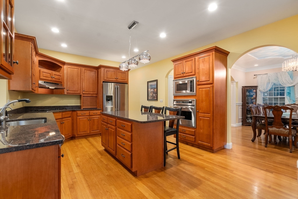 15 Beaver Brook Road Canton, MA 02021 - Photo 9 of 33 a kitchen with stainless steel appliances granite countertop a refrigerator a sink dishwasher a dining table and chairs with wooden floor
