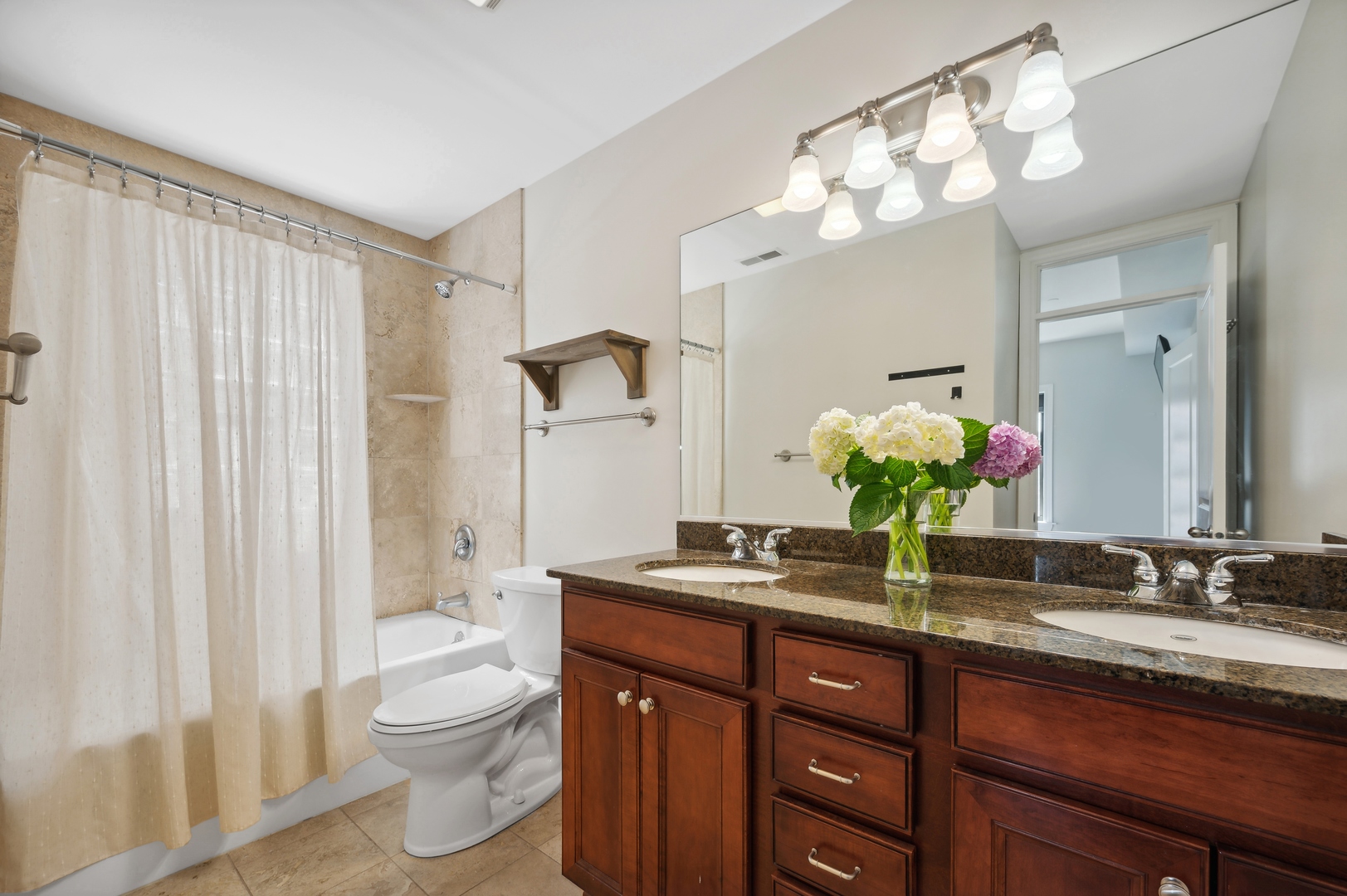 1610 West Byron Street, Unit 2 Chicago, IL 60613 - Photo 17 of 21 a bathroom with a granite countertop sink a toilet and a mirror